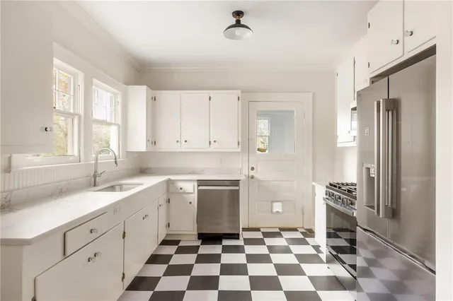 a kitchen with a sink a refrigerator and cabinets