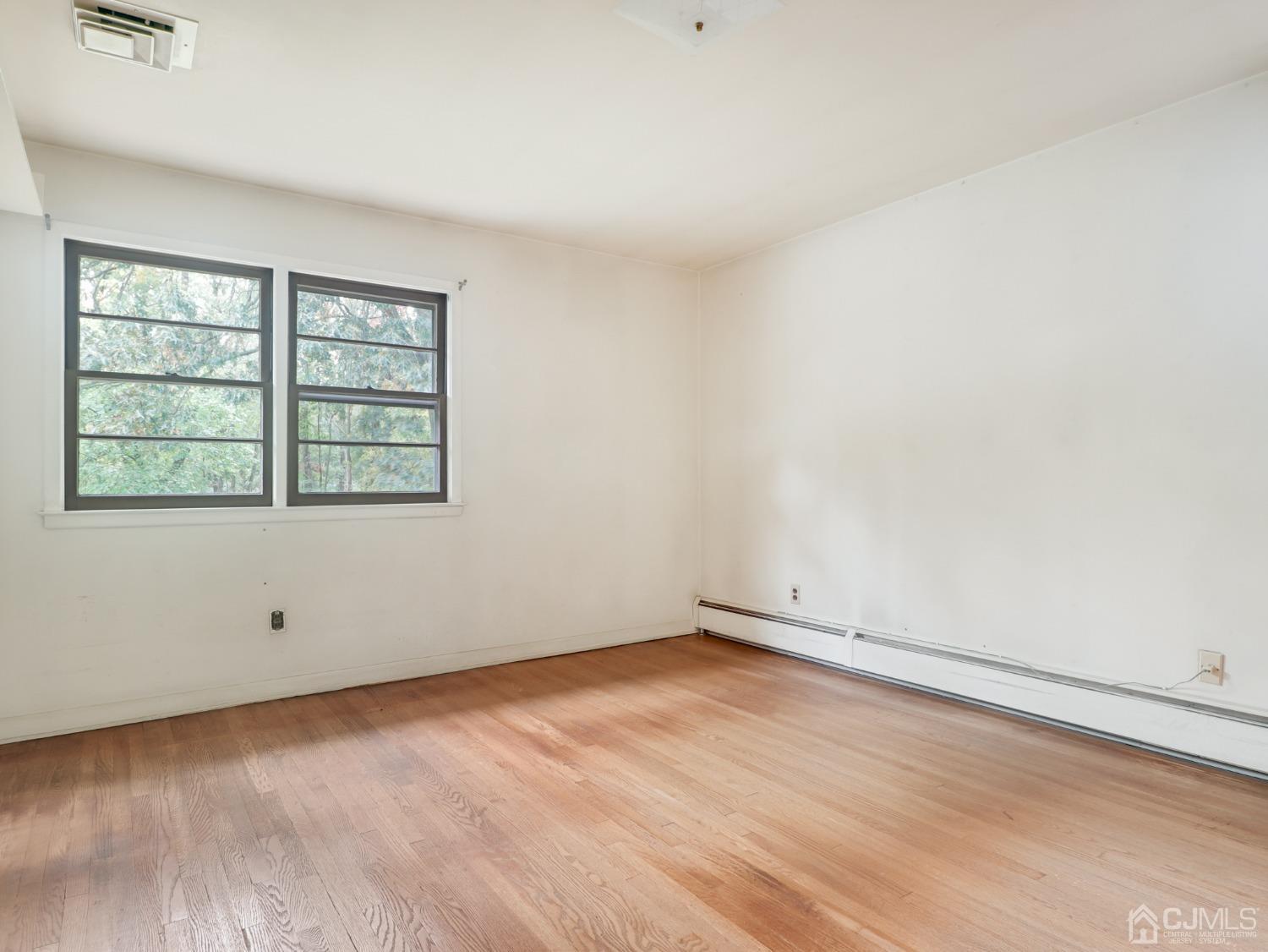 29 Princeton Road Cranford, NJ 07016 - Photo 11 of 24 an empty room with wooden floor and windows