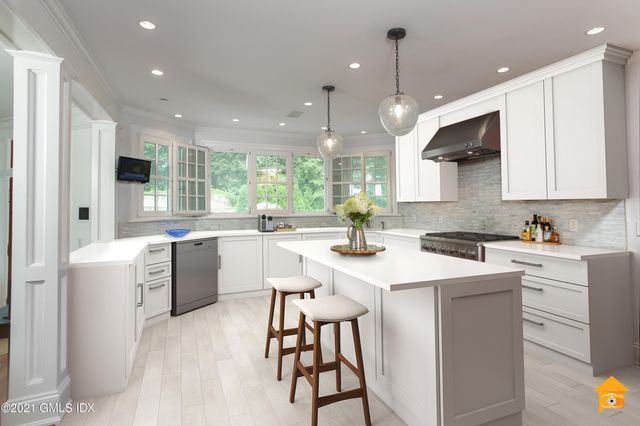 a kitchen with a sink a center island cabinets and a window