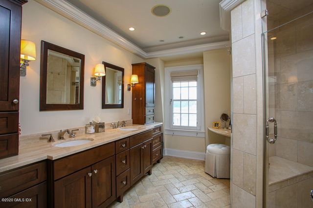a spacious bathroom with a double vanity sink a large mirror and a bathtub