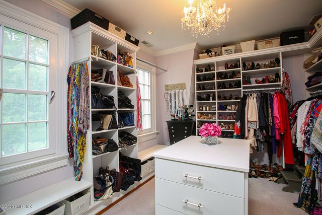 a view of walk in closet with clothes and shoes