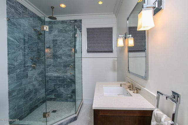 a bathroom with a sink mirror and shower