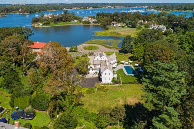 an aerial view of residential houses with outdoor space and lake view