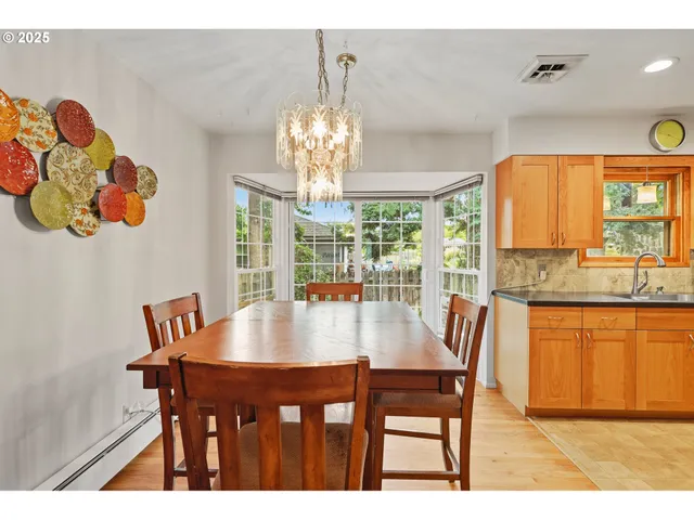 a view of a dining room with furniture a chandelier and wooden floor
