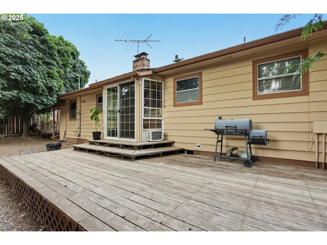 a view of a house with wooden deck and furniture