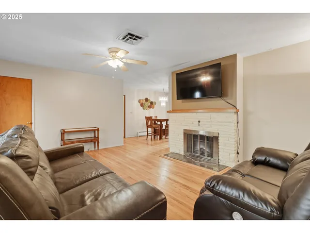 a living room with furniture a flat screen tv and a fireplace