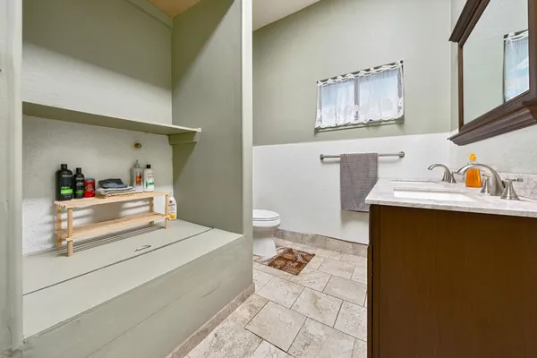 a bathroom with a granite countertop toilet and a sink