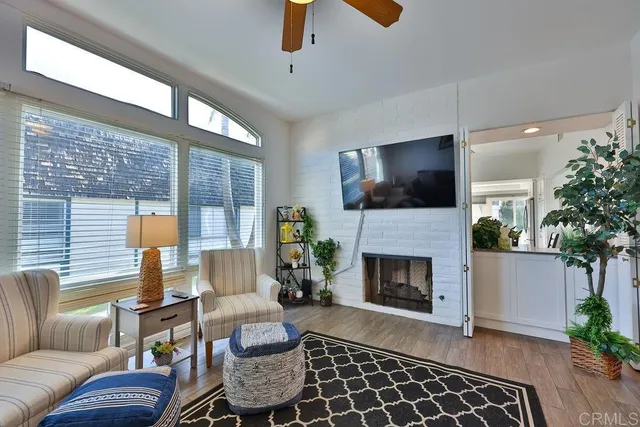a living room with furniture a fireplace and a potted plant