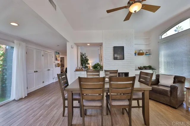 a kitchen with stainless steel appliances granite countertop a stove a sink a refrigerator with white cabinets and wooden floor