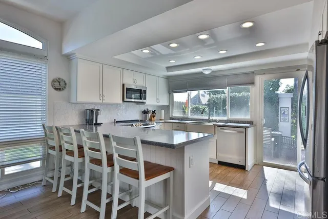 a kitchen with granite countertop white cabinets a sink and dishwasher