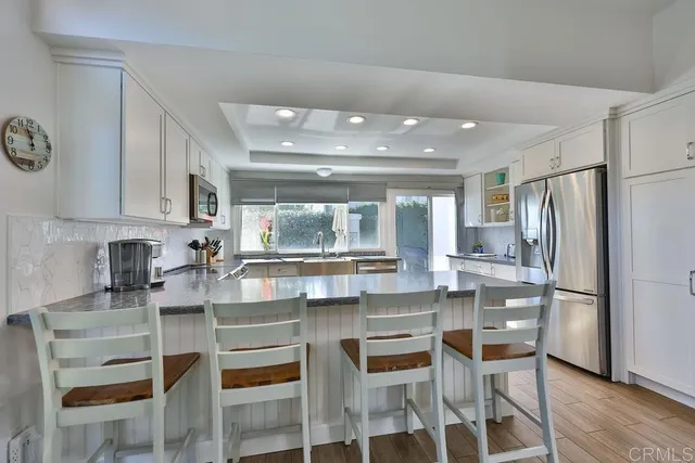 a kitchen with granite countertop a stove top oven sink and cabinets