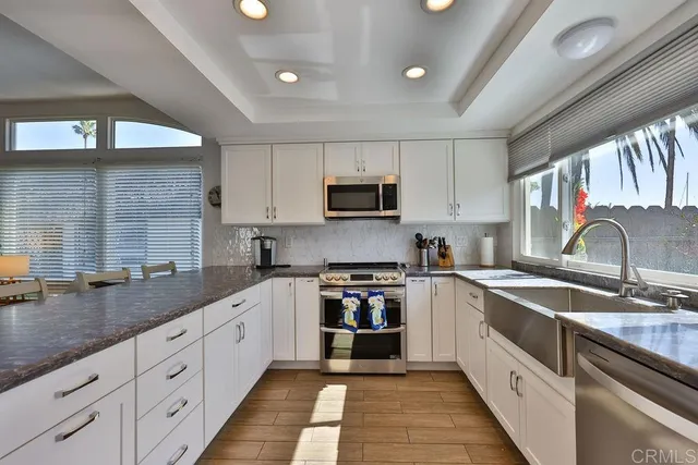 a kitchen with granite countertop a refrigerator stove top oven and sink