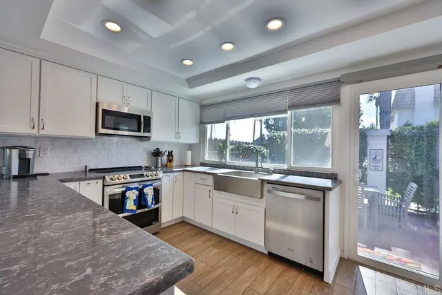 a living room with couches and a dining table with wooden floor