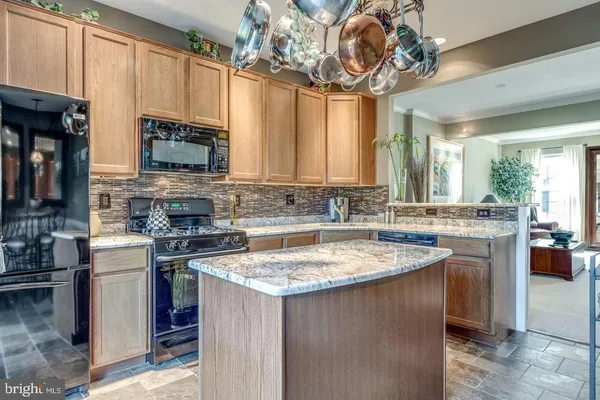 a kitchen with stainless steel appliances granite countertop a sink a stove top oven a counter space and cabinets