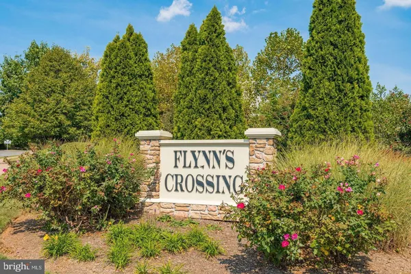 a sign that is sitting in front of flowers