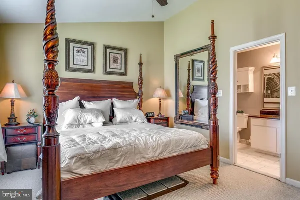 a bedroom with a large bed and a chandelier