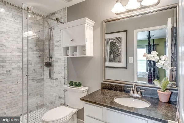 a bathroom with a granite countertop toilet sink and shower