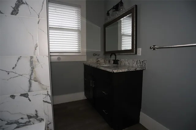 a bathroom with a granite countertop sink toilet and mirror