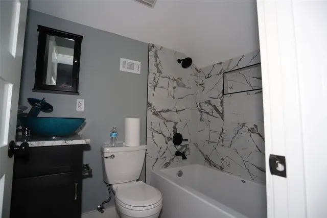 a bathroom with a toilet a sink and bathtub