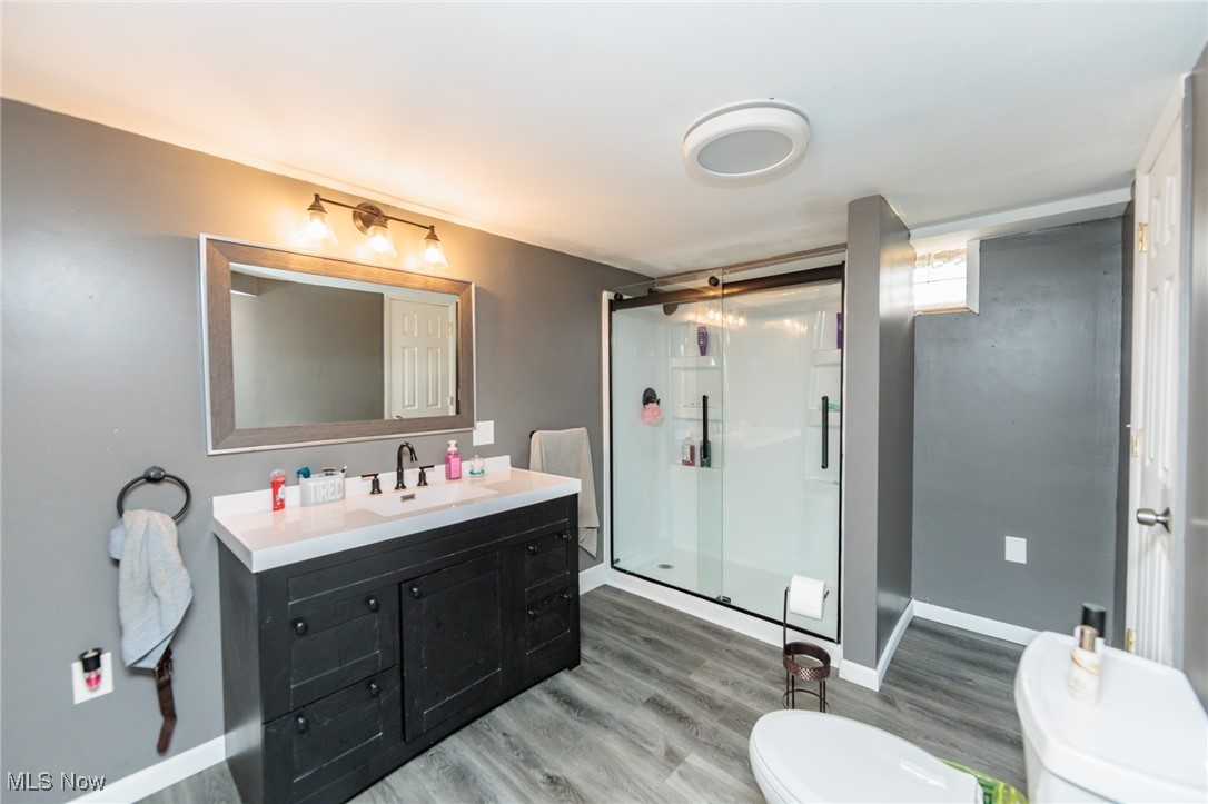 3443 Dentzler Road Parma, OH 44134 - Photo 42 of 48 Bathroom with a shower stall, baseboards, toilet, wood finished floors, and vanity