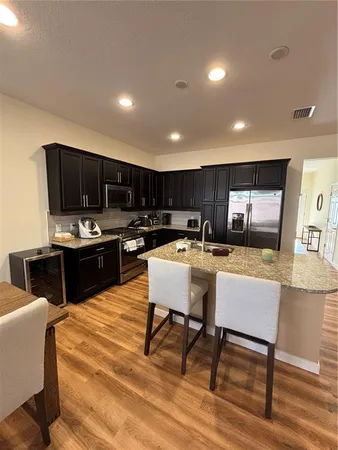 a kitchen with a table chairs refrigerator and microwave