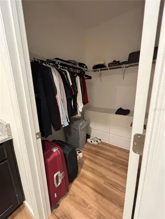 a view of walk in closet with clothes and shoes