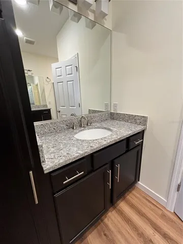 a bathroom with a granite countertop sink a mirror and vanity