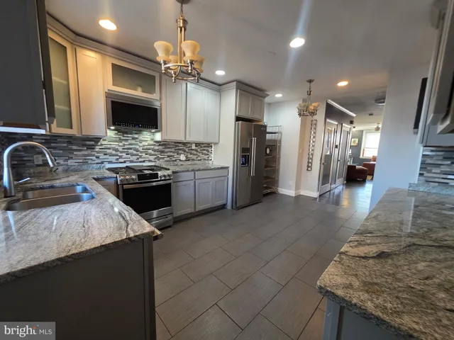 a kitchen with granite countertop a stove top oven cabinetry and granite counter tops