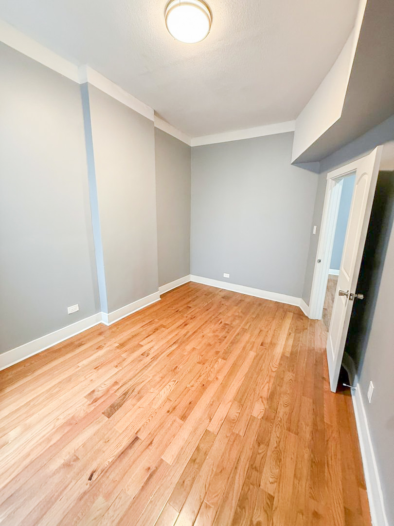 438 East 49th Street, Unit 3 Chicago, IL 60615 - Photo 12 of 18 a view of empty room with wooden floor and fan