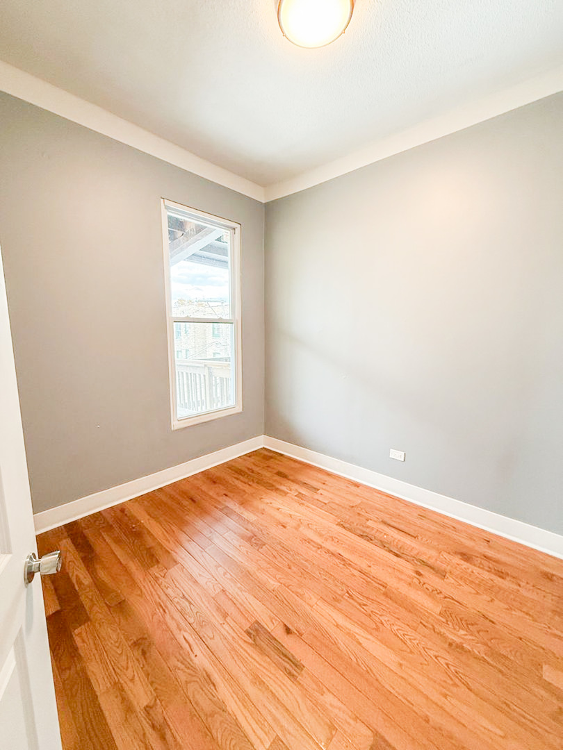 438 East 49th Street, Unit 3 Chicago, IL 60615 - Photo 16 of 18 a view of empty room with wooden floor and fan