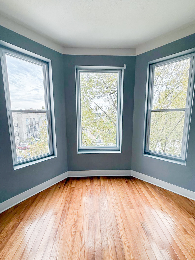 438 East 49th Street, Unit 3 Chicago, IL 60615 - Photo 17 of 18 a view of an empty room with wooden floor and a window