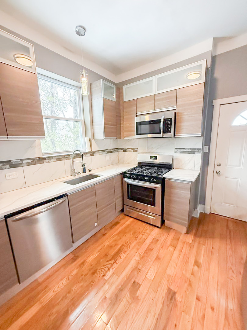 438 East 49th Street, Unit 3 Chicago, IL 60615 - Photo 2 of 18 a kitchen with a refrigerator a sink and a stove