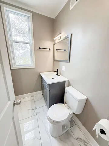 a white toilet sitting next to a bathroom sink
