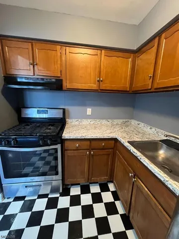 a kitchen with granite countertop stainless steel appliances a sink and a counter space