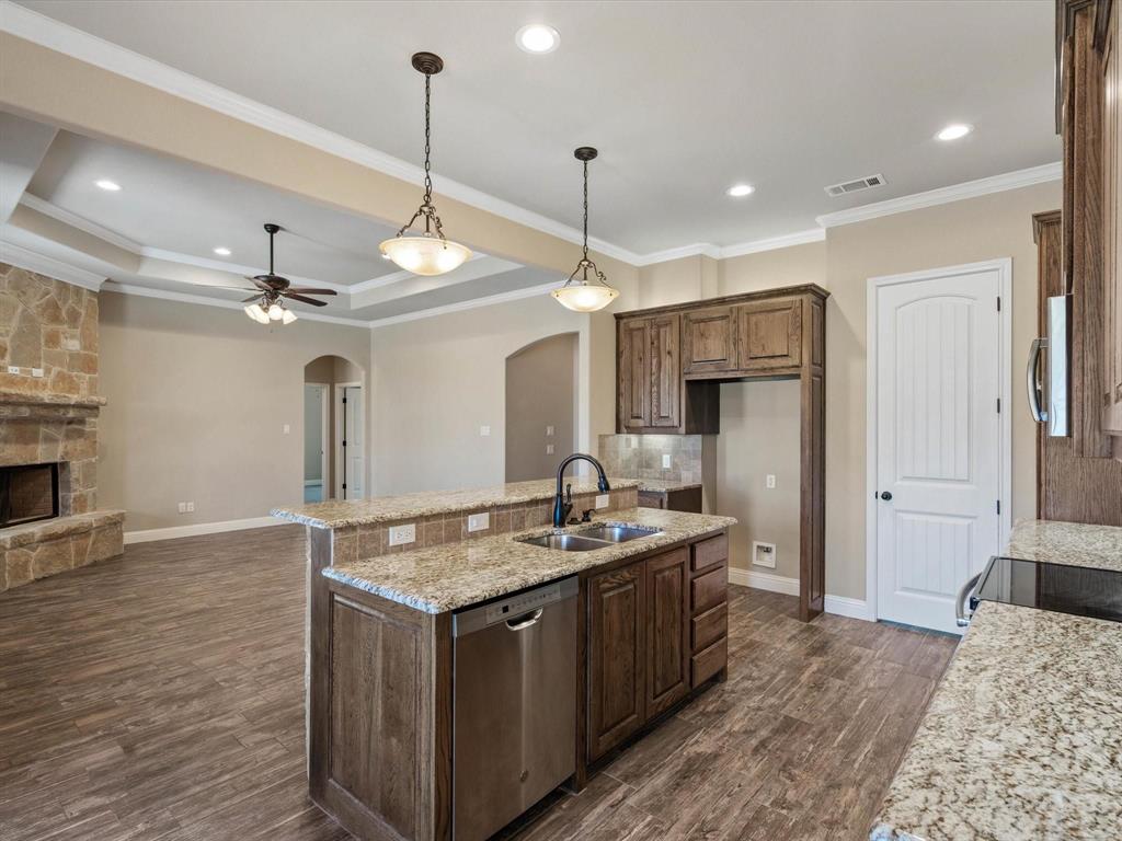 229 Etta Lane Springtown, TX 76082 - Photo 11 of 39 a kitchen with kitchen island a sink stainless steel appliances and a fireplace