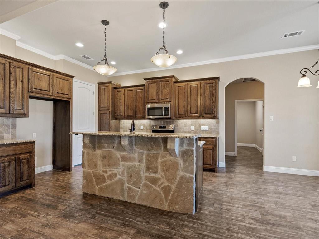 229 Etta Lane Springtown, TX 76082 - Photo 12 of 39 a view of kitchen with stainless steel appliances granite countertop cabinets and wooden floor