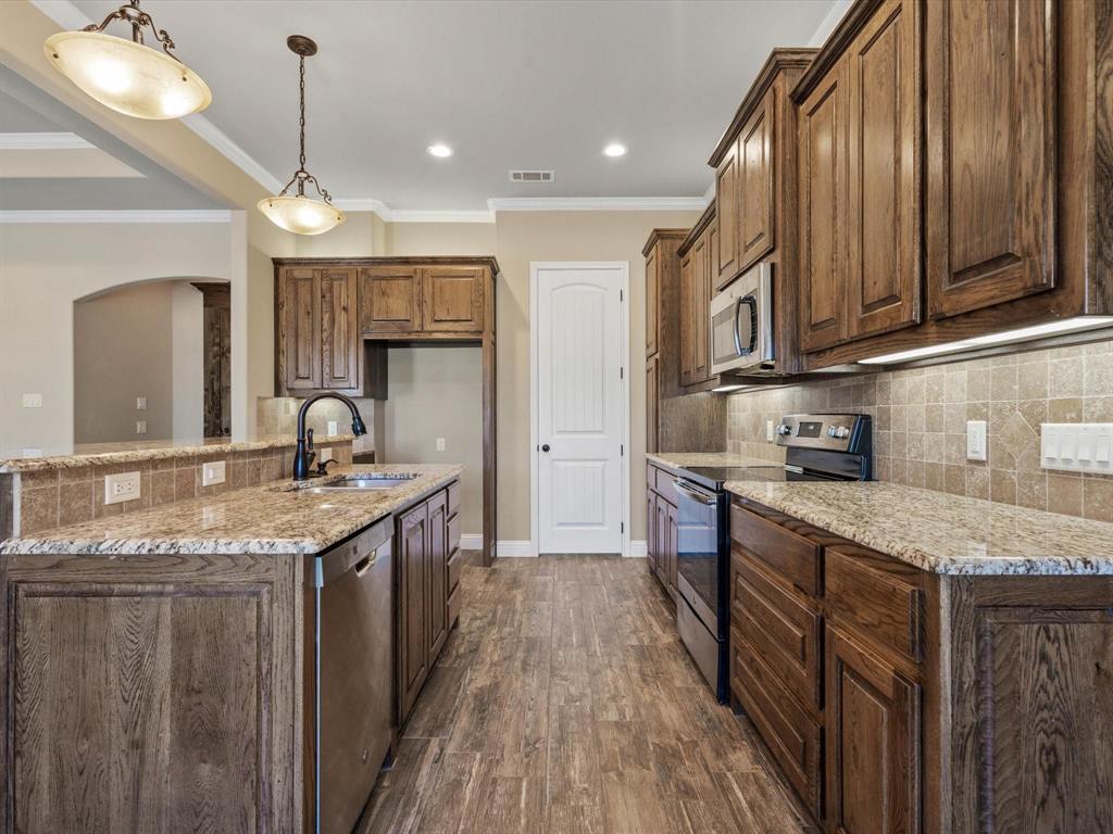 229 Etta Lane Springtown, TX 76082 - Photo 15 of 39 a kitchen with stainless steel appliances granite countertop a sink a stove and a wooden floors