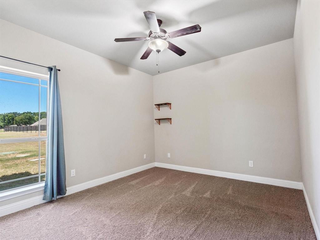 229 Etta Lane Springtown, TX 76082 - Photo 17 of 39 en empty room with windows and ceiling fan