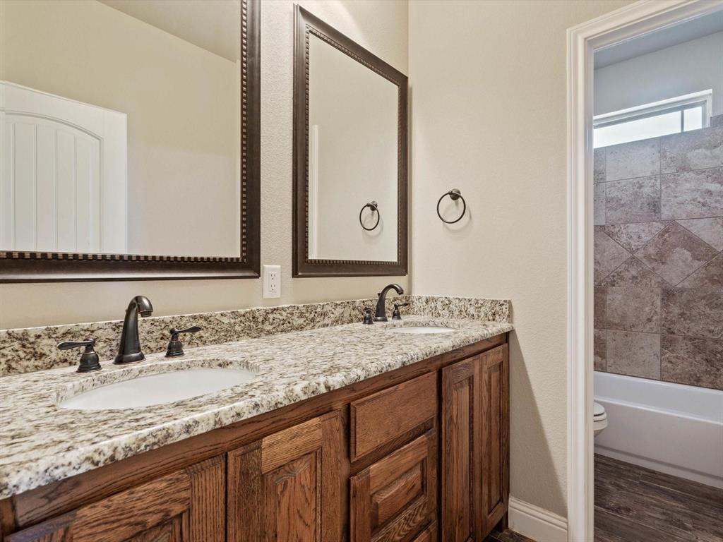 229 Etta Lane Springtown, TX 76082 - Photo 18 of 39 a bathroom with a granite countertop sink and a mirror white cabinet