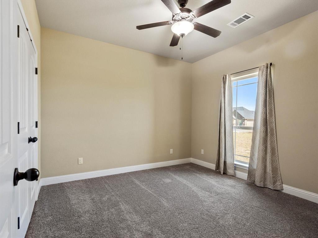 229 Etta Lane Springtown, TX 76082 - Photo 20 of 39 an empty room with a ceiling fan and a window