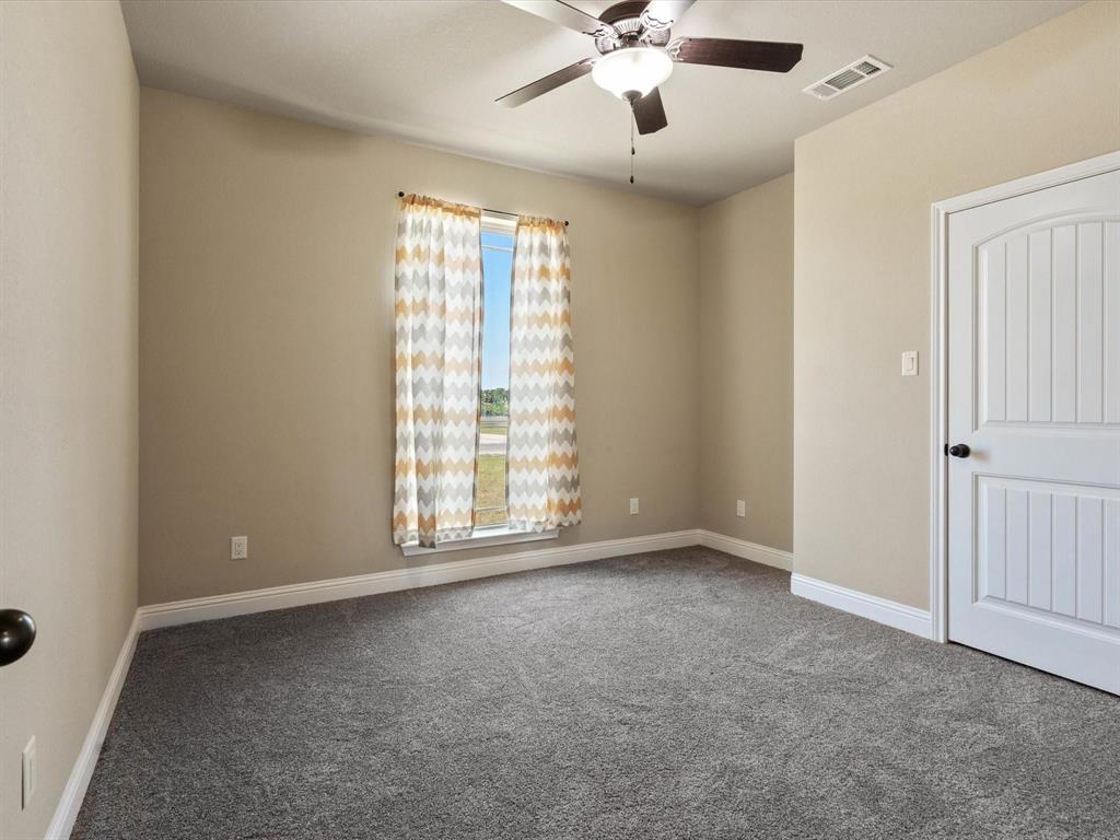 229 Etta Lane Springtown, TX 76082 - Photo 21 of 39 an empty room with windows and fan