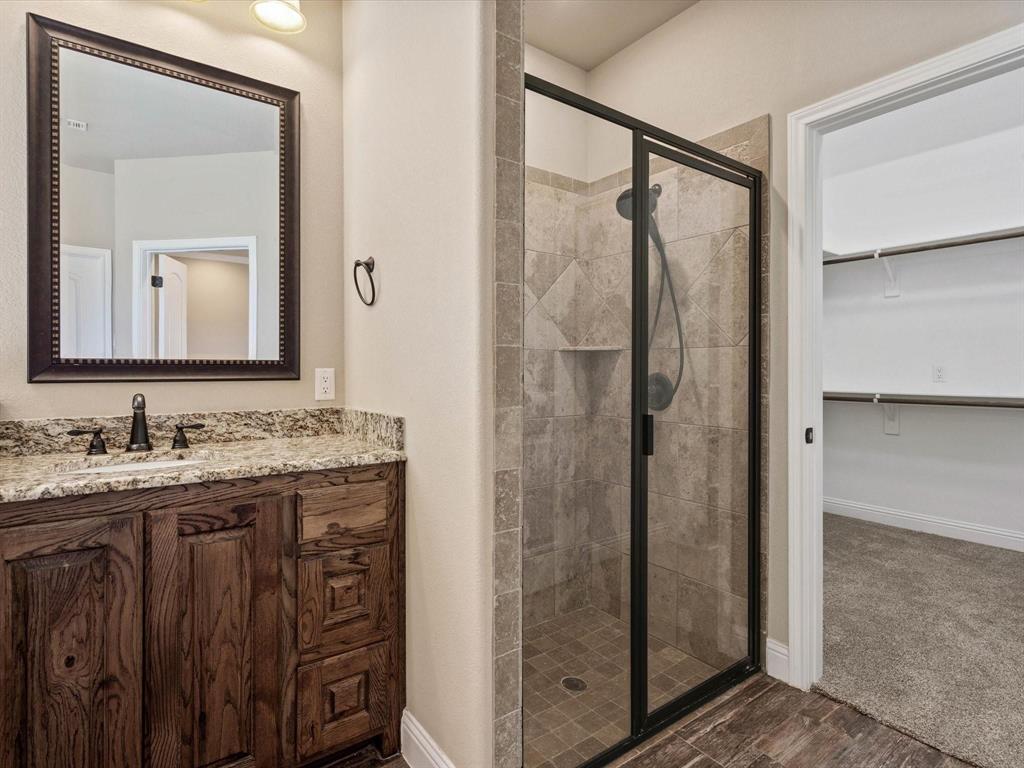 229 Etta Lane Springtown, TX 76082 - Photo 31 of 39 a bathroom with a granite countertop sink mirror and shower