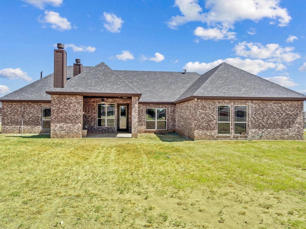 229 Etta Lane Springtown, TX 76082 - Photo 36 of 39 a front view of a house with a garden