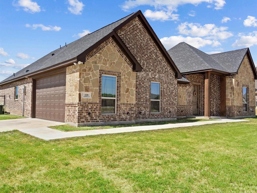 229 Etta Lane Springtown, TX 76082 - Photo 4 of 39 a front view of house with yard and trees in the background