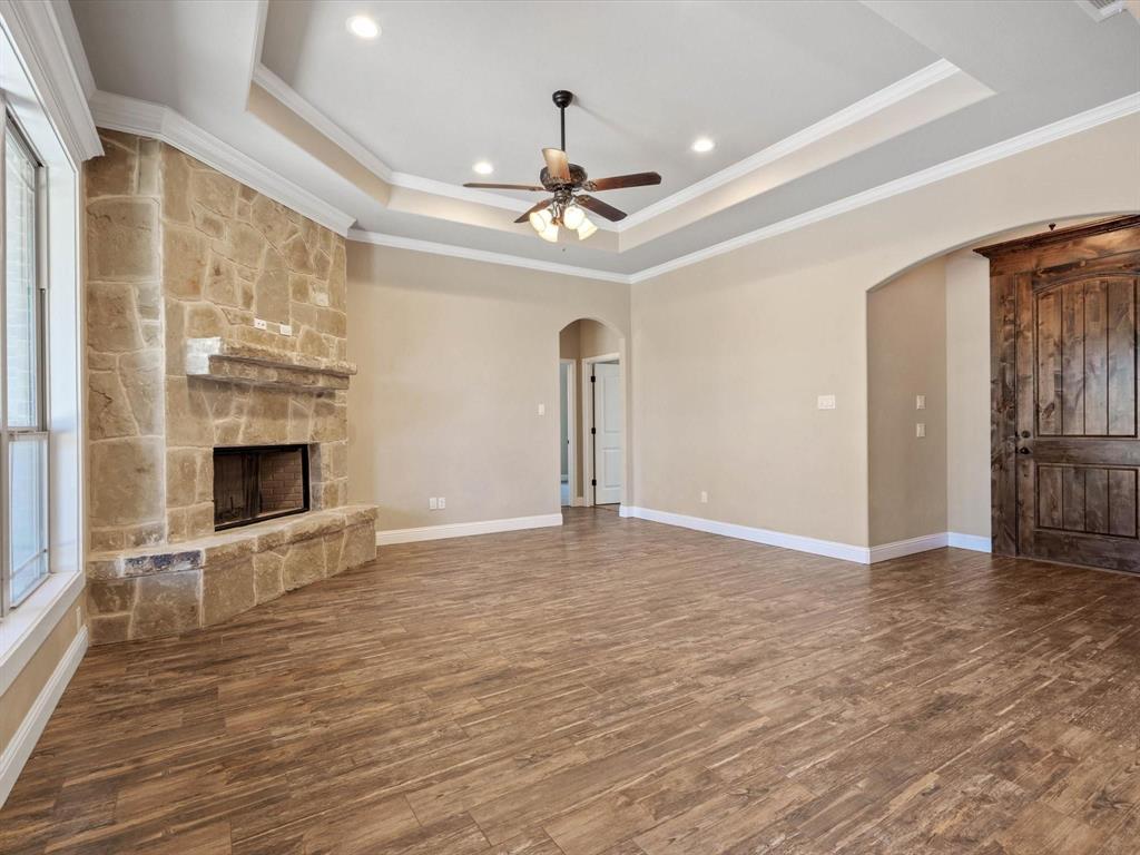 229 Etta Lane Springtown, TX 76082 - Photo 8 of 39 a view of an empty room with a fireplace and a chandelier fan