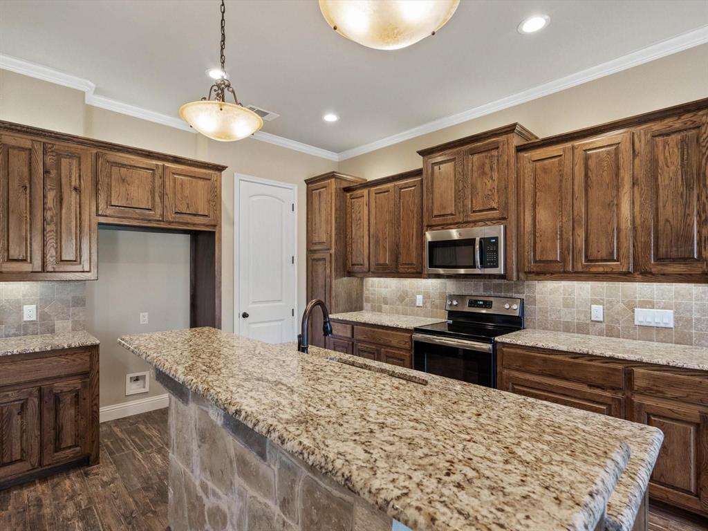 229 Etta Lane Springtown, TX 76082 - Photo 10 of 39 a kitchen with stainless steel appliances granite countertop a stove top oven a sink dishwasher a refrigerator and cabinets with wooden floor