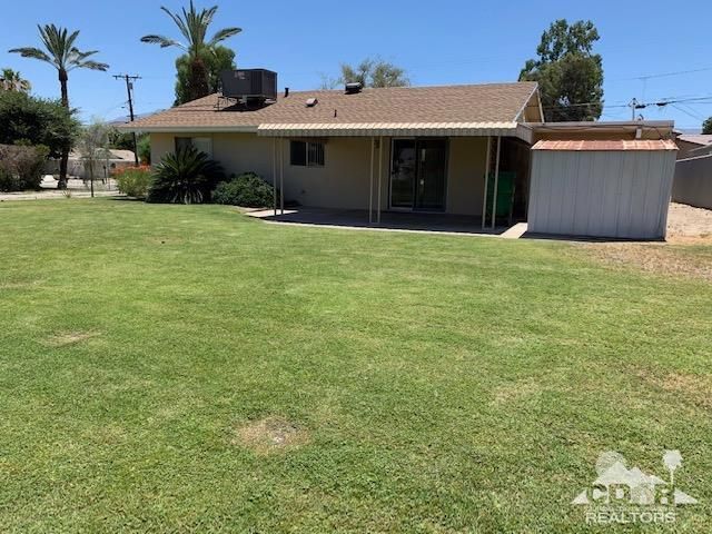 a view of a house with a yard and potted plants