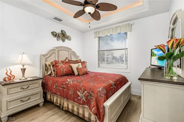 a bedroom with a bed a chandelier and a window