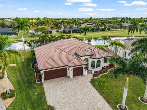 a kitchen with stainless steel appliances kitchen island granite countertop a dining table chairs and white cabinets