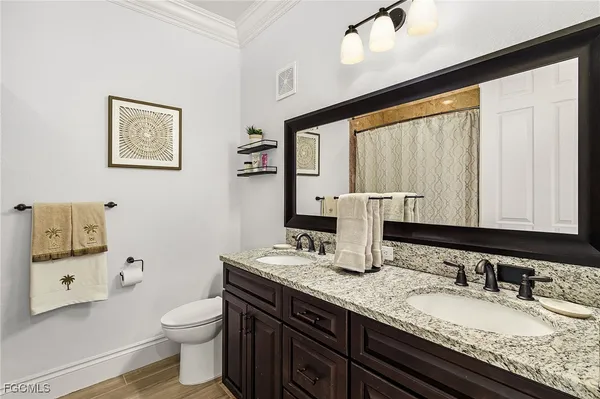 a bathroom with a granite countertop sink mirror vanity and toilet